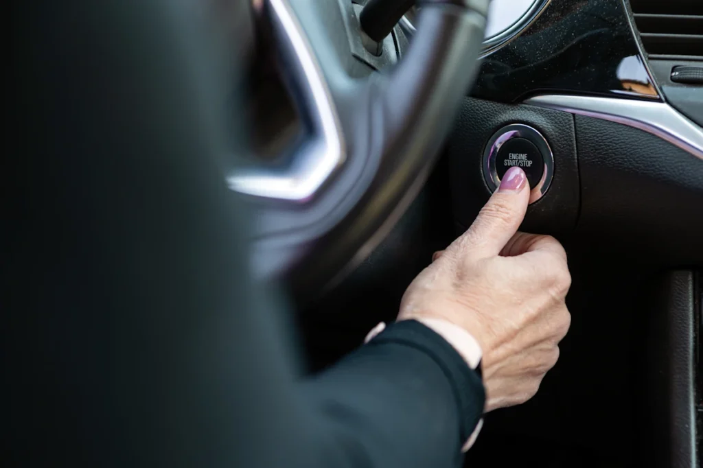 Une femme qui va appyuer sur un bouton dans sa voiture