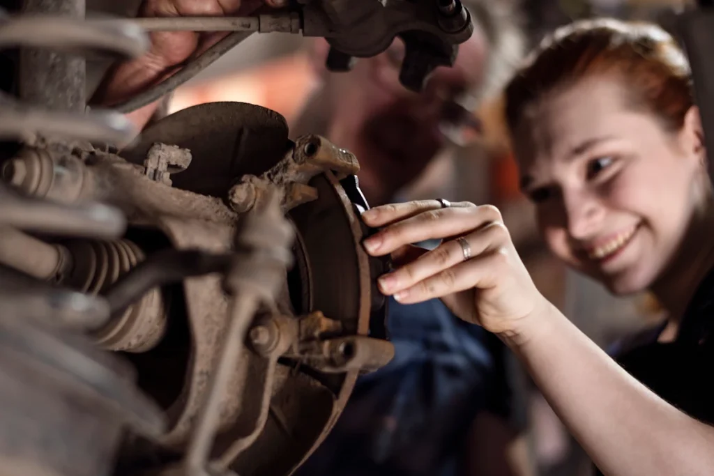 Une femme qui entretien une plaquette de frein de voiture