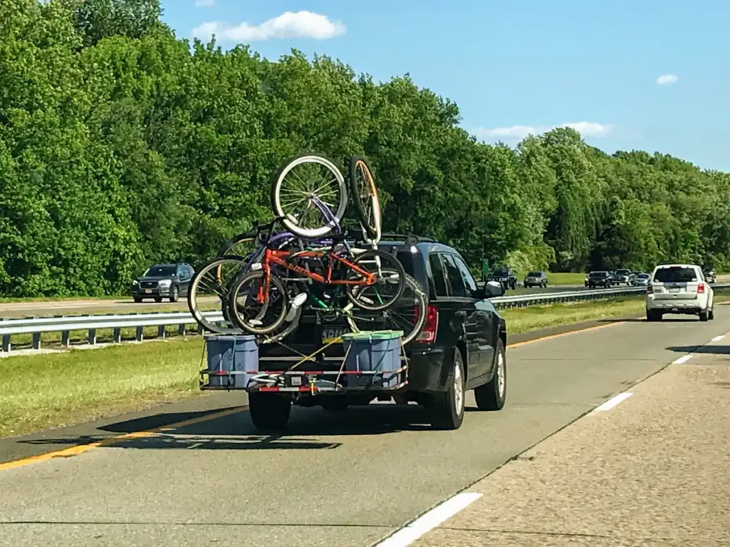 Une voiture avec une remorque à l'arrière remplie de vélos