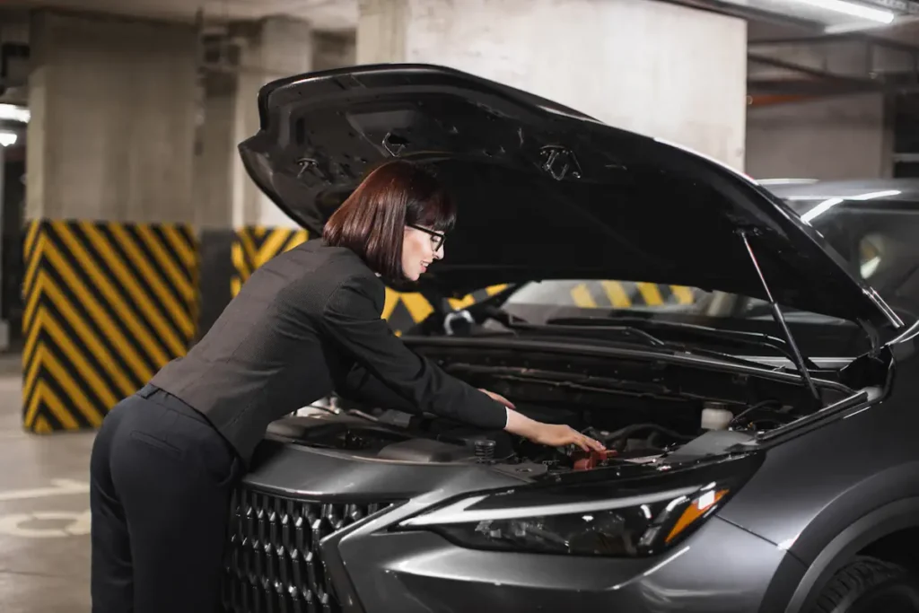 Une femme qui regarde sous le capot d'une voiture