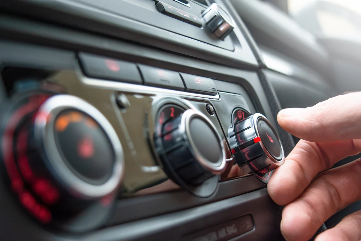 Un homme qui règle le chauffage d'une voiture