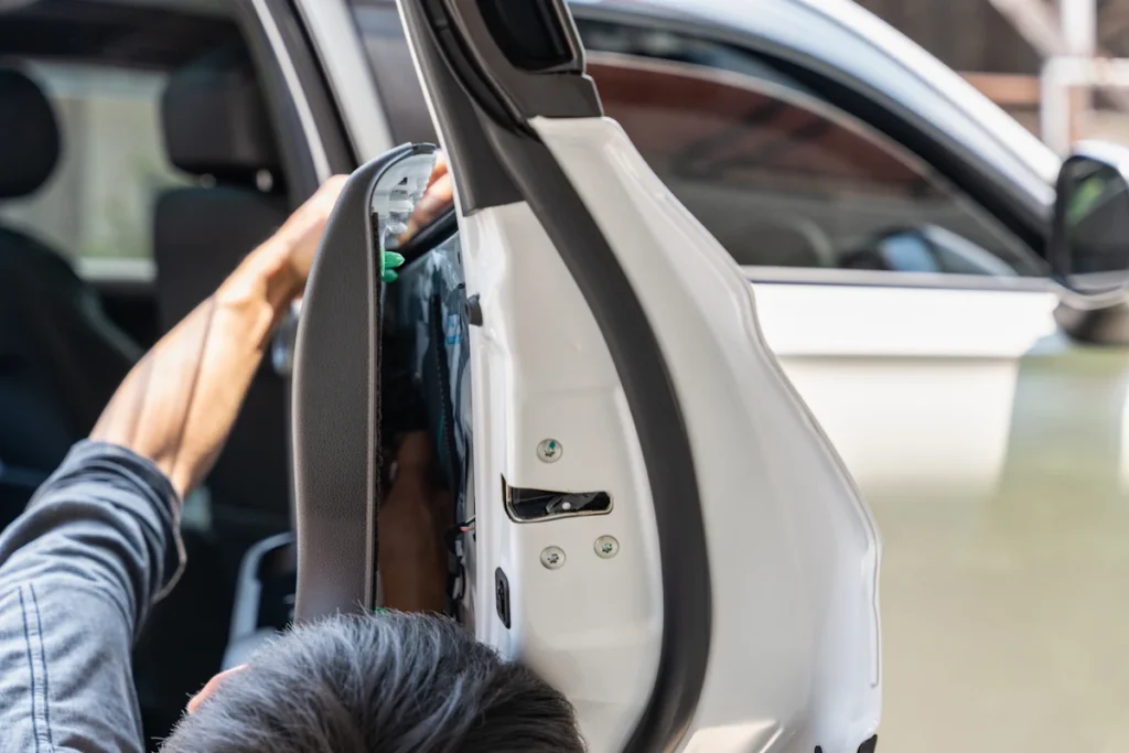 Un homme qui remplace la garniture d'une porte de voiture