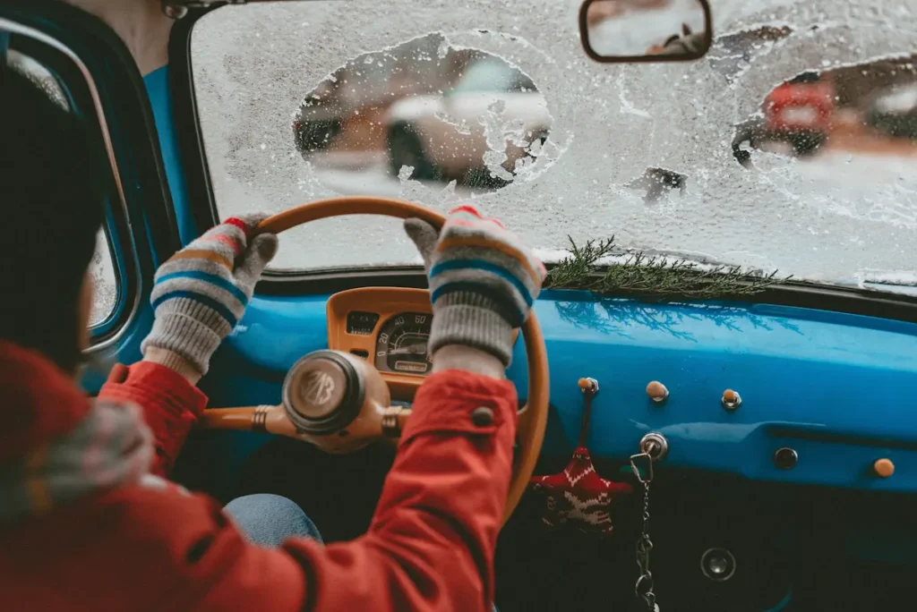 Une personne qui conduit une voiture avec une partie du pare-brise gelée