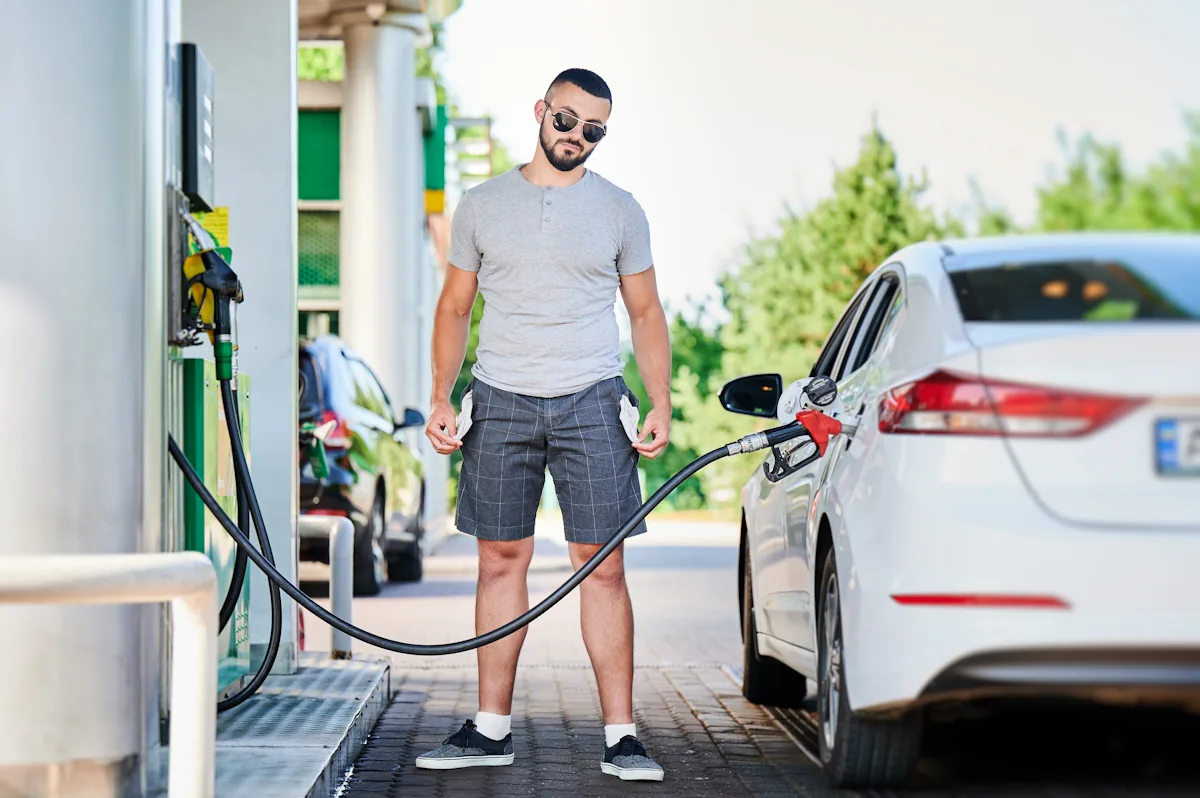 Un homme qui prend du carburant à un station-service