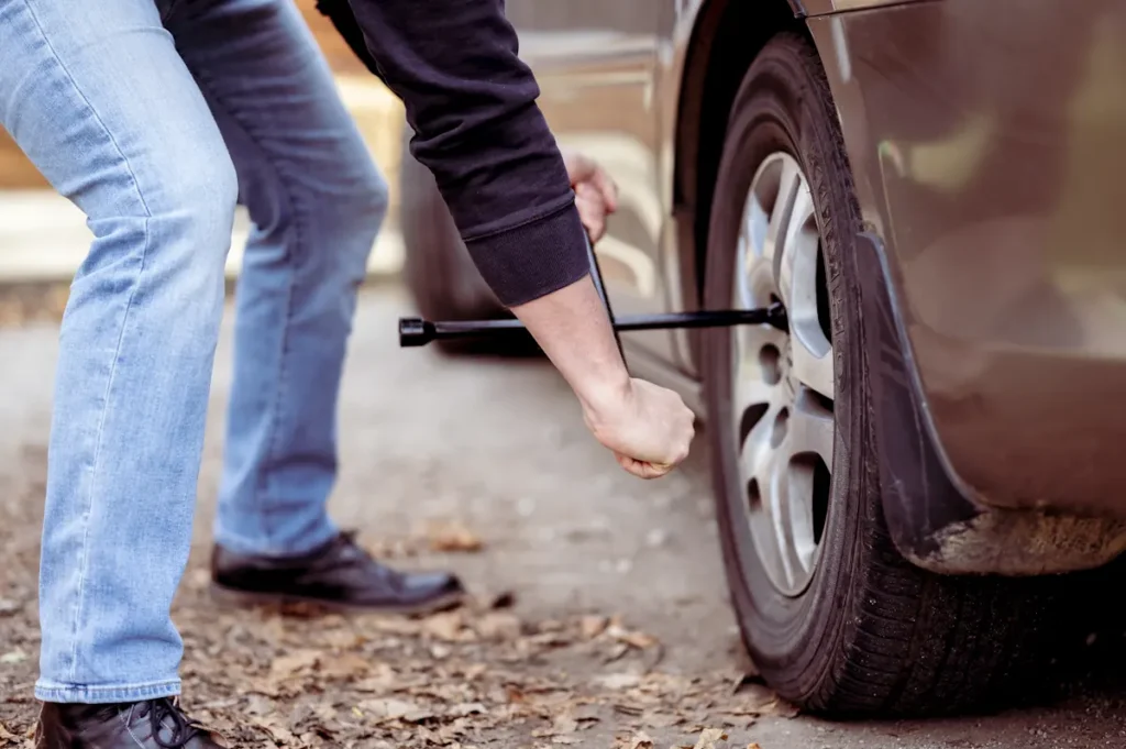 Un homme qui change une roue de sa voiture