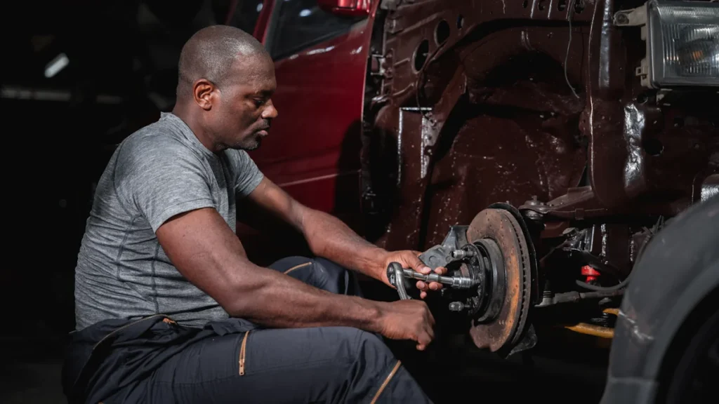 Un homme qui répare les freins d'une voiture
