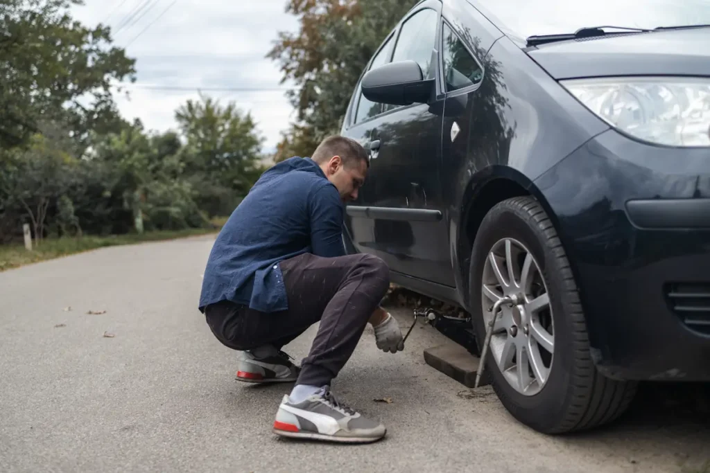 Un homme qui change un pneu de voiture