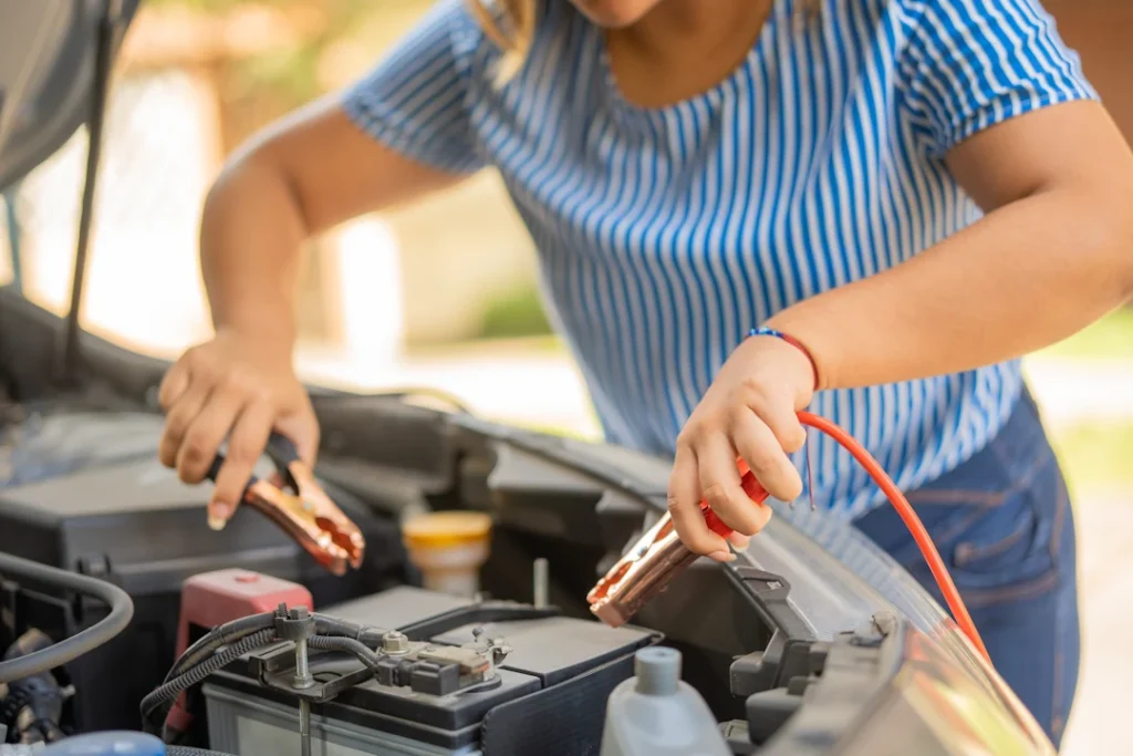 Une femme qui charge la batterie de sa voiture