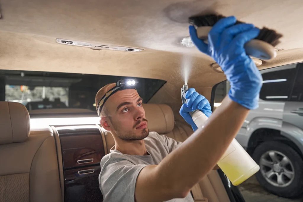 Un homme qui travaille sur le ciel de toit d'une voiture