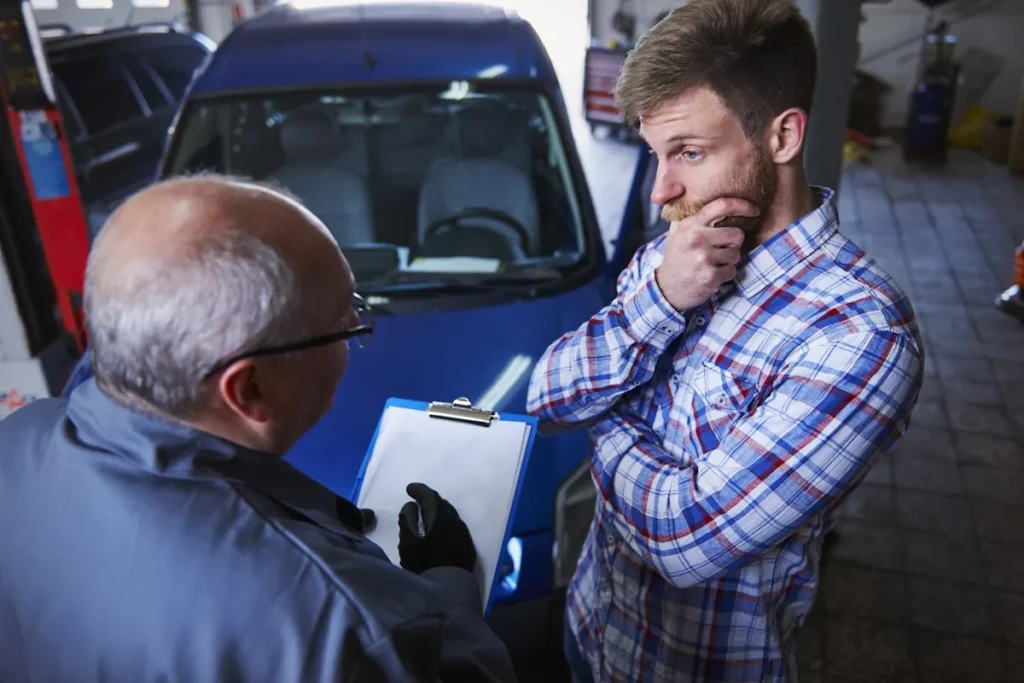 Un homme qui discute avec un autre du contrôle technique de sa voiture d'occasion