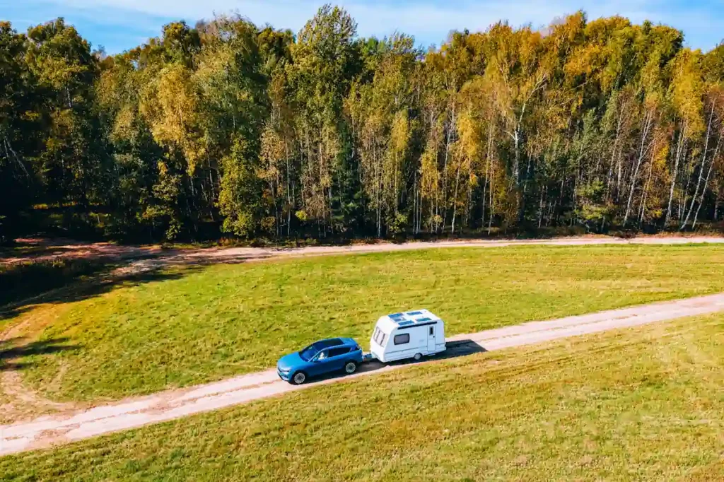 Une personne qui conduit une voiture avec une remorque à l'arrière