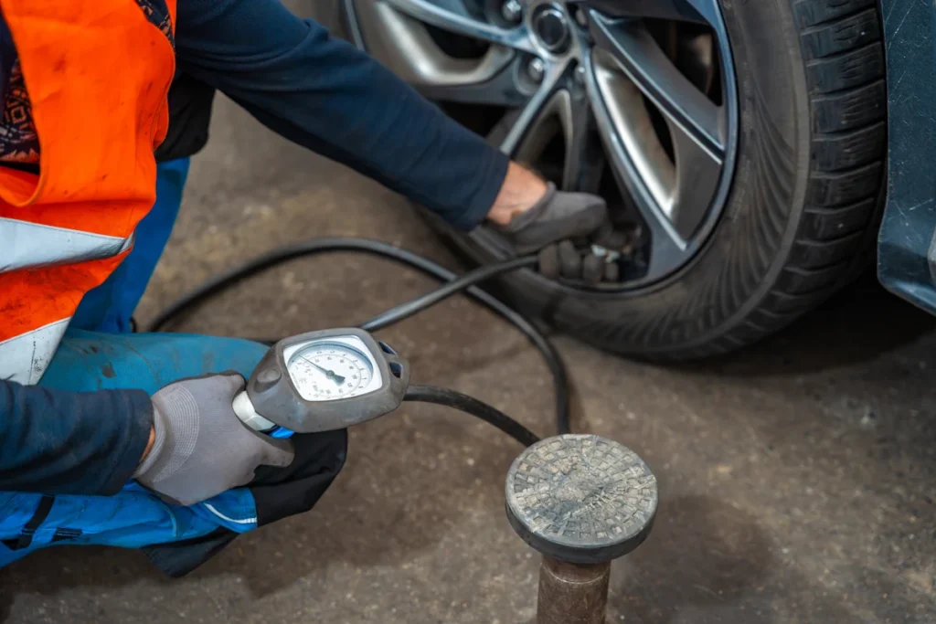 Un homme qui gonfle les pneus d'une voiture