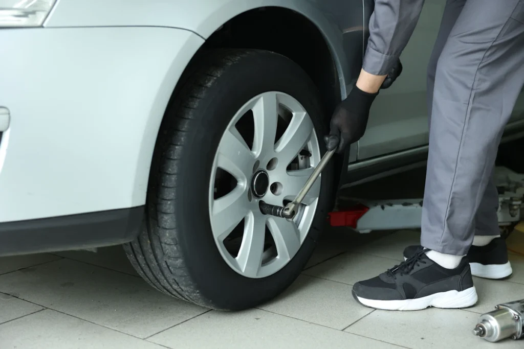 Un mécanicien qui regarde la roue avant d'une voiture