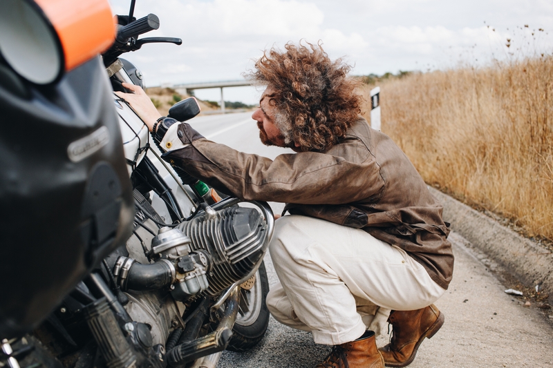 homme qui regarde sa moto